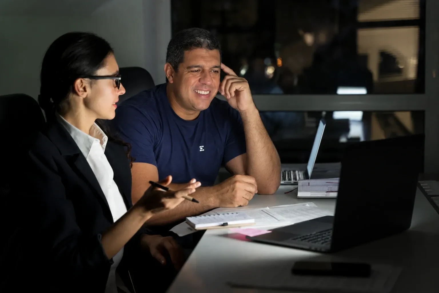 Geraldo Durães, fundador do grupo EcomSmart, conversando com uma colega diante do notebook